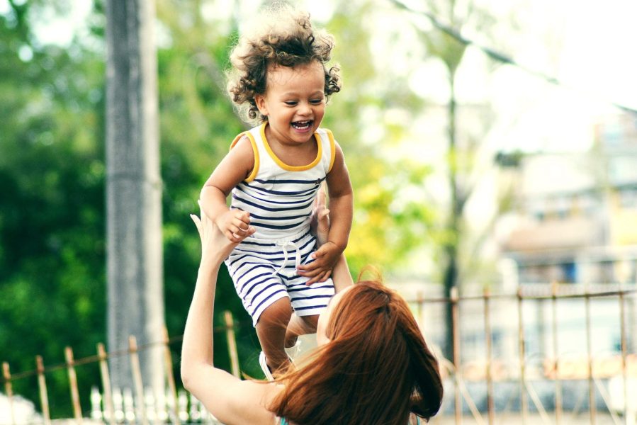 A mother raising her daughter up in the air